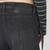 Los vaqueros de denim negro con tiras
